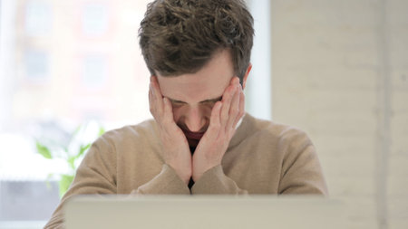 Close Up of Man having Headache while using Laptopの写真素材