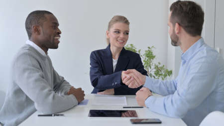 Mixed Race Business People Shaking Hands after Discussion
