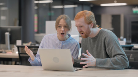 Couple Reacting to Loss on Laptopの写真素材