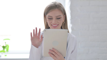 Portrait of Video Call on Tablet by Lady Doctor in Officeの写真素材