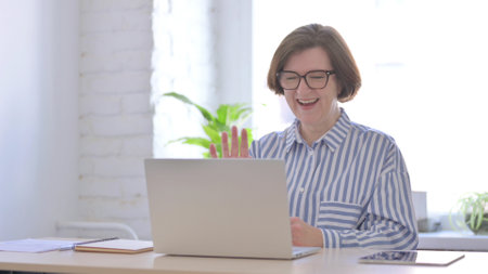 Online Video Call by Senior Woman in Officeの写真素材