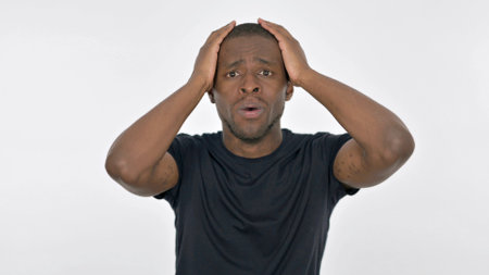 Disappointed Young African Man Reacting Loss on White Backgroundの写真素材