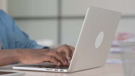 Close Up of Young African Man Typing on Laptop
