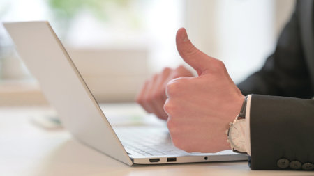 Close up of Middle Aged Businessman using Laptop, Showing Thumbs Upの写真素材
