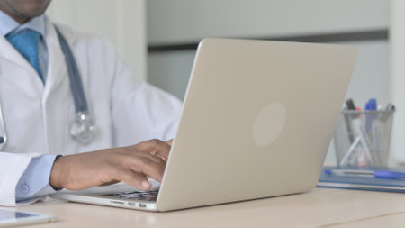 Close Up of African-American Doctor Typing on Laptopの写真素材