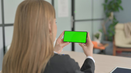 Businesswoman Watching Smartphone with Chroma Keyの写真素材