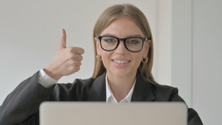 Thumbs Up by Lady Doctor Using Laptop in Clinicの写真素材