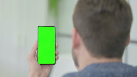 Mature Adult Man Using Smartphone with Green Screenの写真素材