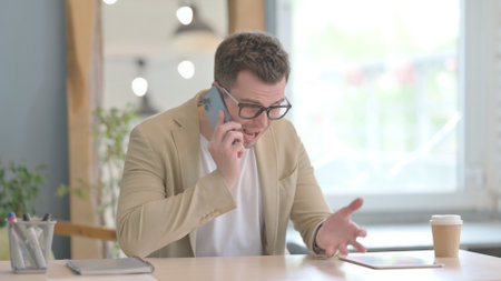 Annoyed Young Businessman on Smartphoneの写真素材