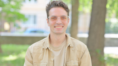 Outdoor Portrait of Smiling Casual Young Man Looking at Cameraの写真素材