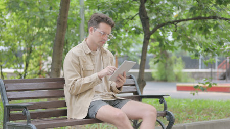 Modern Young Man using Tablet Outdoorの写真素材