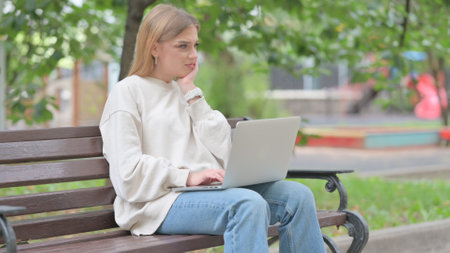Young Woman Working on Laptop Outdoorの写真素材