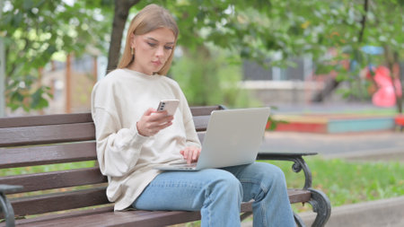 Young Woman Working on Laptop and Smartphoneの写真素材