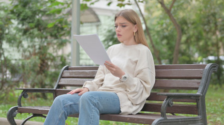 Casual Young Woman Reading Contract Outdoorの写真素材