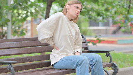 Young Woman Sitting Outdoor with Back Painの写真素材
