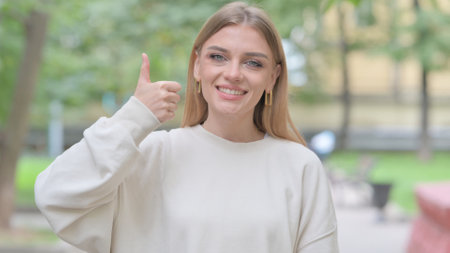 Outdoor Portrait of Woman with Thumbs Upの写真素材
