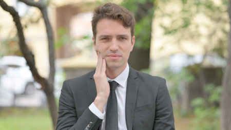 Outdoor Portrait of Businessman with Tooth Infectionの写真素材