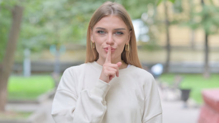 Outdoor Portrait of Woman with Finger on Lipsの写真素材