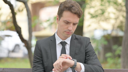 Young Businessman using Smart Watch Outdoorの写真素材