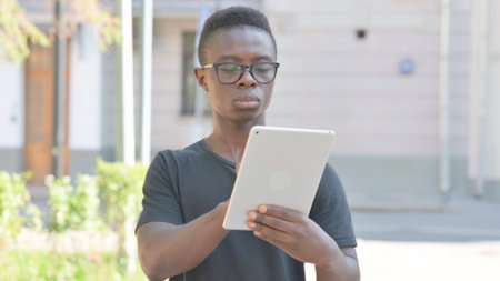 Young African Man using Tablet Outdoorの写真素材