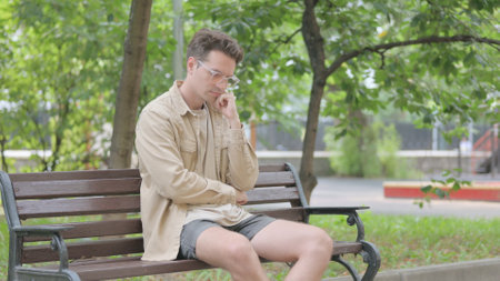 Young Man Sitting on Benchの写真素材