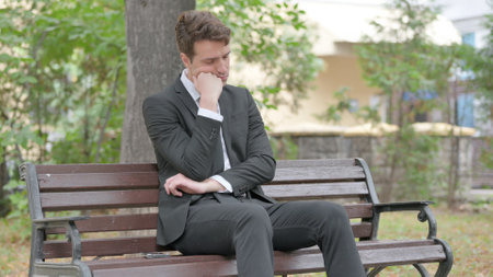 Young Businessman Sleeping while Sitting Outdoorの写真素材
