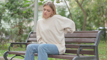 Casual Young Woman Sitting Outdoor with Back Painの写真素材