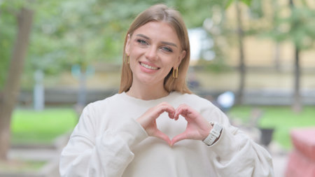 Outdoor Portrait of Woman with Handmade Heartの写真素材