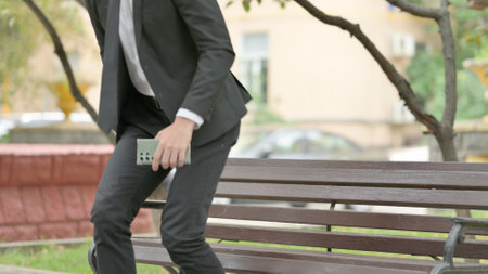 Businessman Standing up and Leaving Bench Outdoorの写真素材