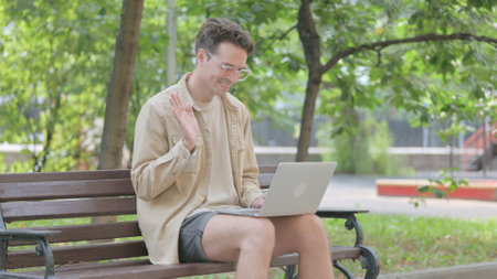 Modern Young Man Doing Online Video Chat Outdoorの写真素材