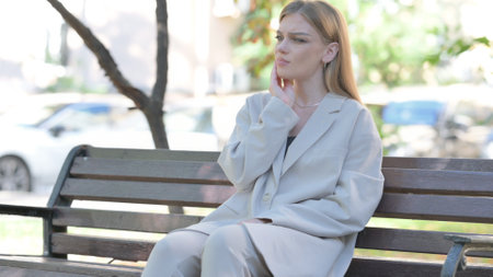 Young Businesswoman with Toothache Sitting on Benchの写真素材