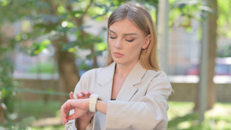 Businesswoman Browsing Smart Watch Outdoorの写真素材