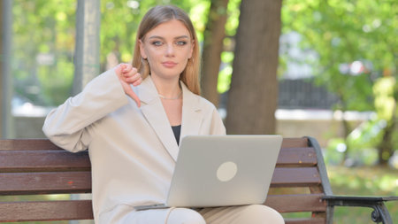 Thumbs Down by Young Businesswoman on Laptop Outdoorの写真素材