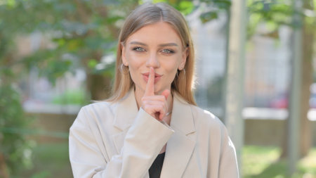 Outdoor Portrait of Businesswoman with Finger on Lipsの写真素材