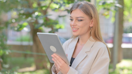 Businesswoman Doing Video Chat on Tablet Outdoorの写真素材