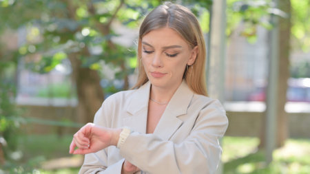Businesswoman Checking Time while Waiting Outdoorの写真素材