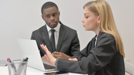 Business People Discussing Project on Laptop in Officeの写真素材