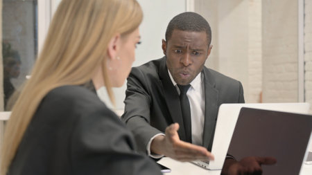 African Businessman Talking with Female Worker in Officeの写真素材