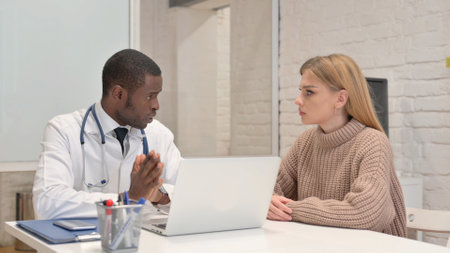 African Doctor Talking with Patient in Clinicの写真素材