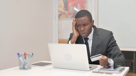 African Businessman Upset with Online Payment Failure on Laptopの写真素材
