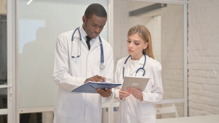 Team of Young Doctors Discussing Medical Reportの写真素材