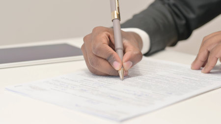 Close Up of African Businessman Writing Document, Paperworkの写真素材
