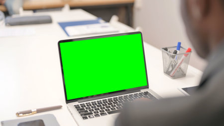 Close up of African Businessman Working on Green Screen Laptopの写真素材