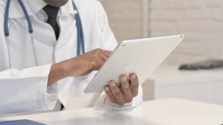 Close up of African Doctor Browsing Internet on Tablet
