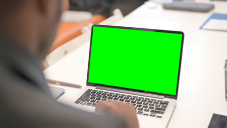 African Man Working on Laptop with Green Screenの写真素材