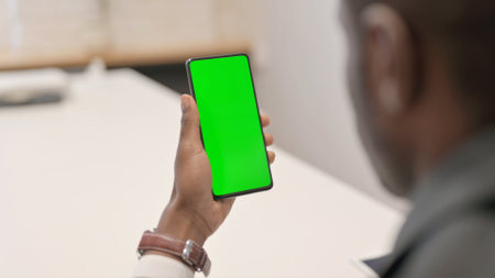 African Man Browsing Smartphone with Green Screenの写真素材