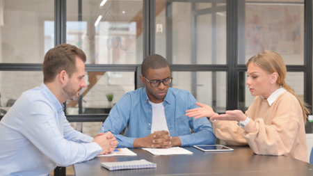 Angry Woman in Discussion with Mixed Race Teammatesの写真素材