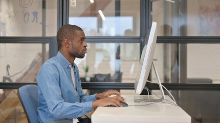 Pensive African Businessman Working on Desktop