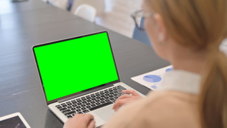 Woman Using Laptop with Green Screenの写真素材