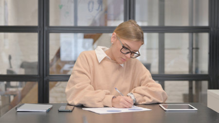 Young Woman Working on Documents in Officeの写真素材